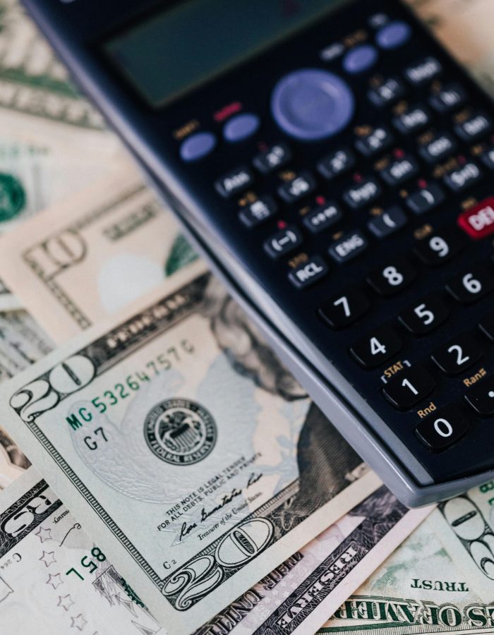 Dollars next to a calculator, illustrating the simplicity of a $500 cash advance with no credit check.