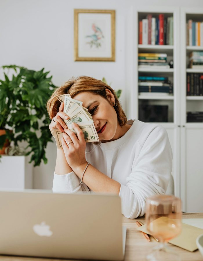 A girl holding dollars, demonstrating the accessibility of a $500 cash advance with no credit check.