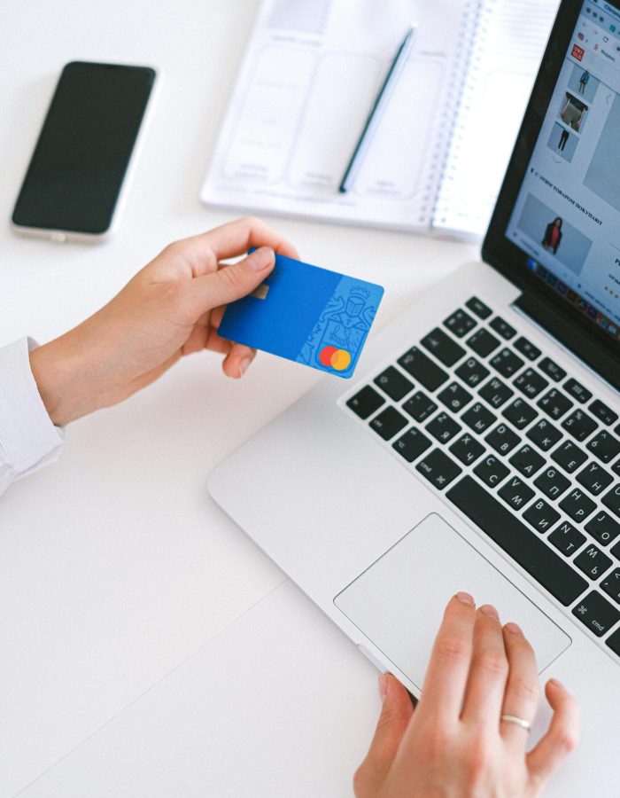 Someone paying bills with a credit card and laptop, highlighting the ease of a $500 cash advance with no credit check